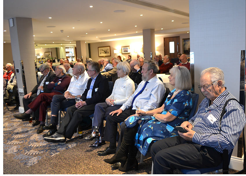 Members seated in rows, listening to a talk